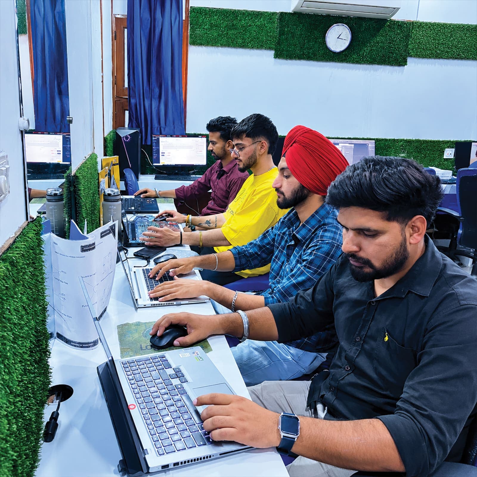 Students coding on laptops at TechCADD